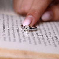 Oval diamond ring hidden halo four claw prong set.