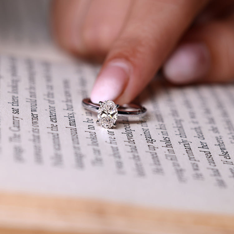 Oval diamond ring hidden halo four claw prong set.