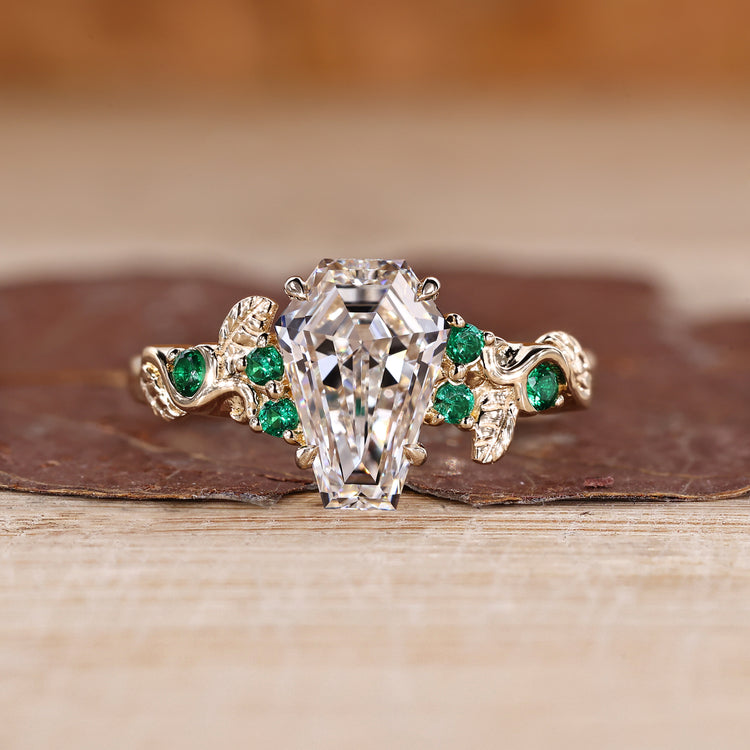 Coffin cut diamond ring green emerald side stones.