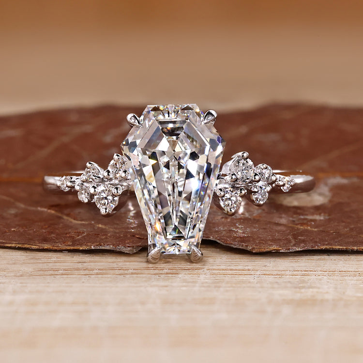 Coffin cut diamond ring round side stones set.