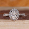 Elongated cushion cut diamond ring with round diamond halo setting.
