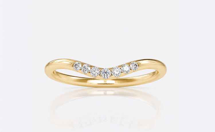 Curved moissanite wedding band shaped to sit flush against an engagement ring
