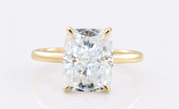 Cushion cut moissanite solitaire ring on a plain solid gold band