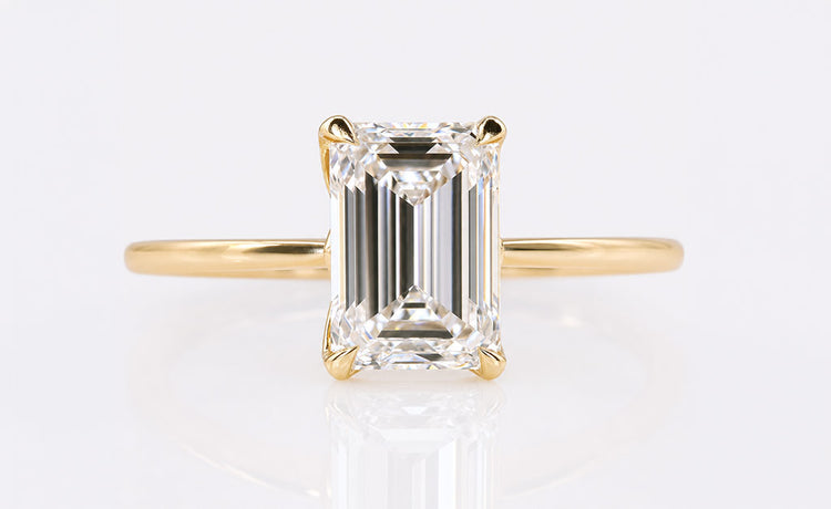 Emerald cut lab grown diamond solitaire ring on a plain solid gold band
