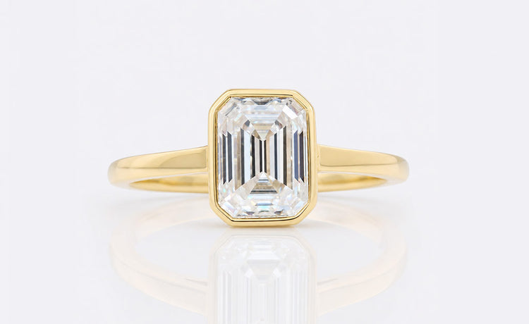 Emerald cut engagement ring with a step cut centre stone in a gold setting