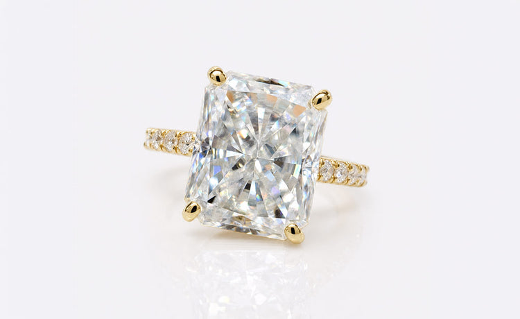 Moissanite engagement ring with a brilliant cut centre stone in a polished gold setting