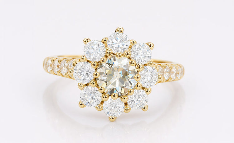Old European cut moissanite halo ring framed by pave set stones