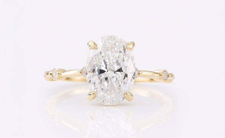 Oval cut moissanite ring with a pave set band in solid gold