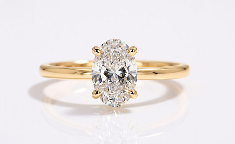 Oval cut lab grown diamond solitaire ring on a plain solid gold band