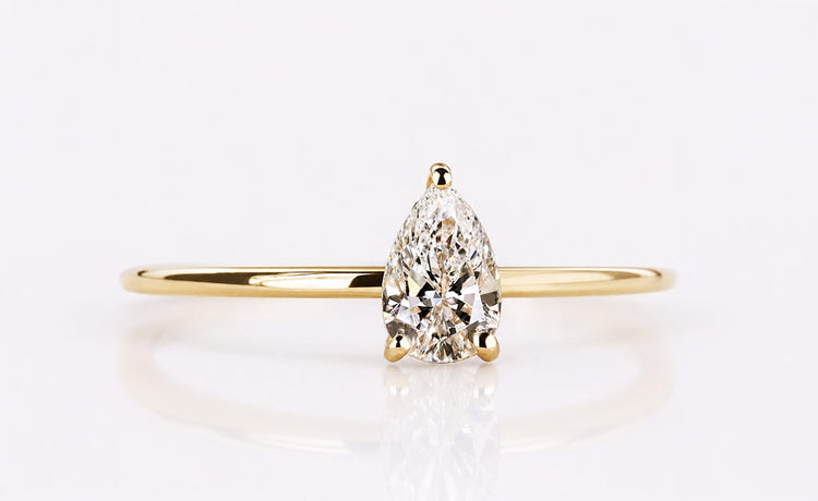 Pear cut lab grown diamond solitaire ring on a plain solid gold band