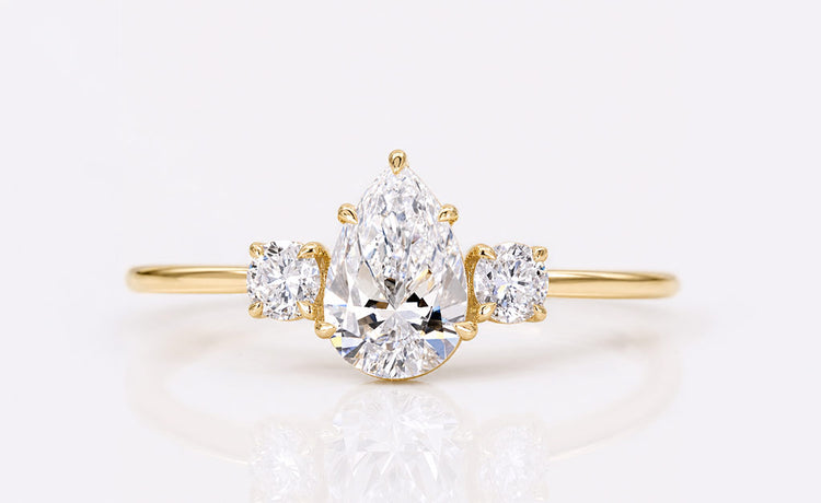Pear cut lab grown diamond three stone ring with two side stones