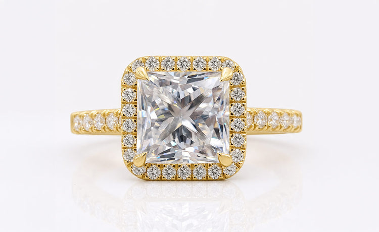 Princess cut moissanite halo ring framed by pave set stones