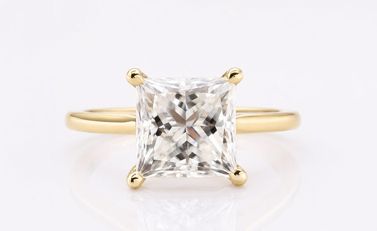 Princess cut moissanite solitaire ring on a plain solid gold band