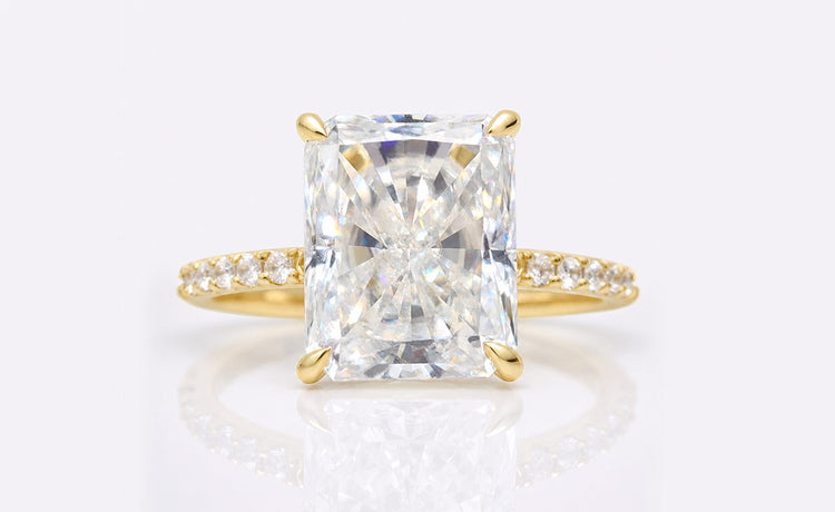 Radiant cut moissanite ring with a pave set band in solid gold