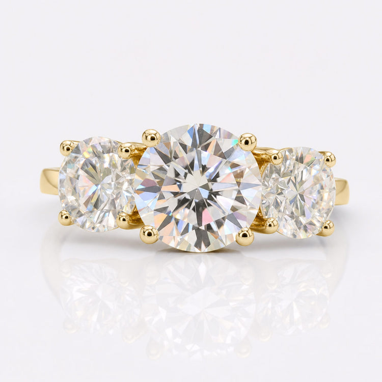 Round cut moissanite three stone ring with a centre stone and two side stones