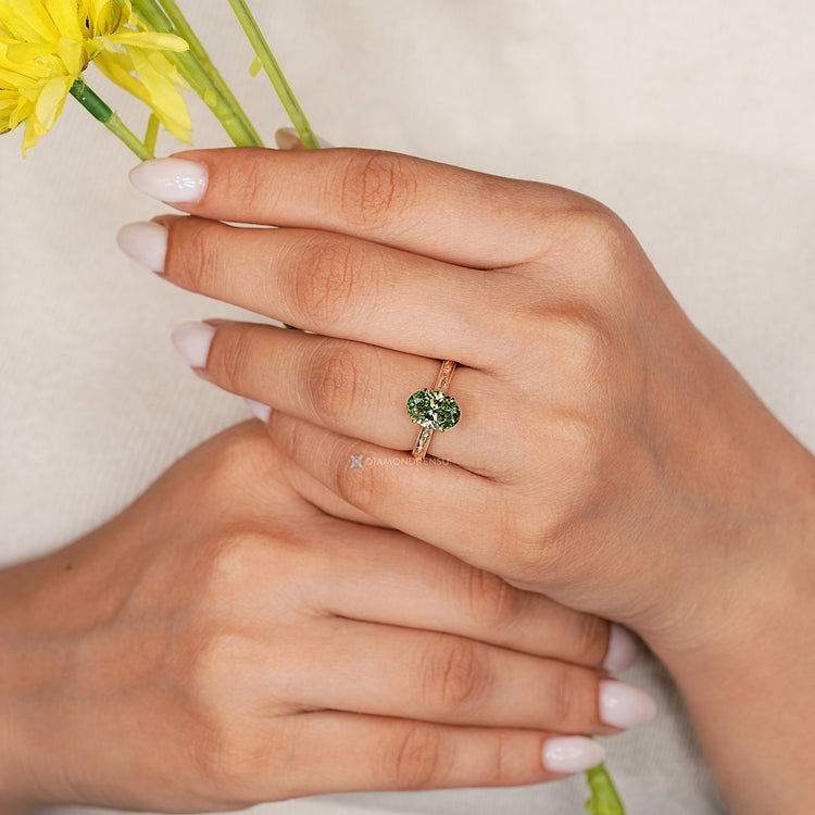 Oval diamond ring with round diamond bridge accent.