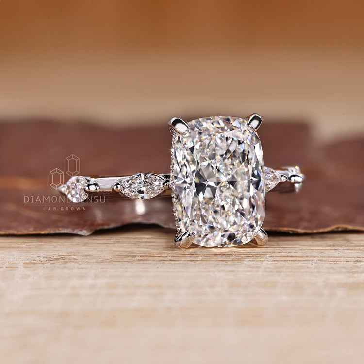 Cushion diamond ring marquise distance pave design.
