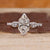 Dutch marquise ring with pear cut side stones in three stone style.
