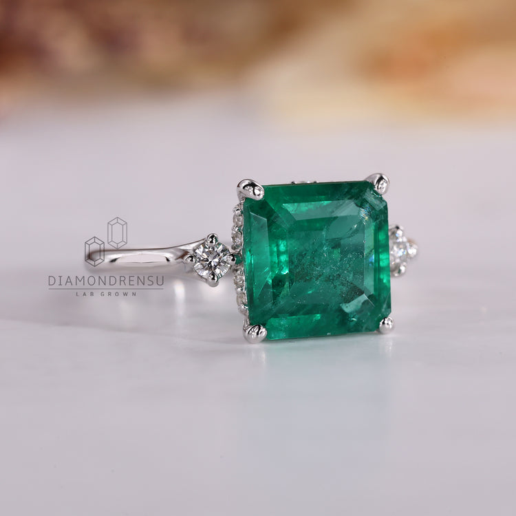 Asscher emerald ring four tab prong hidden halo style.
