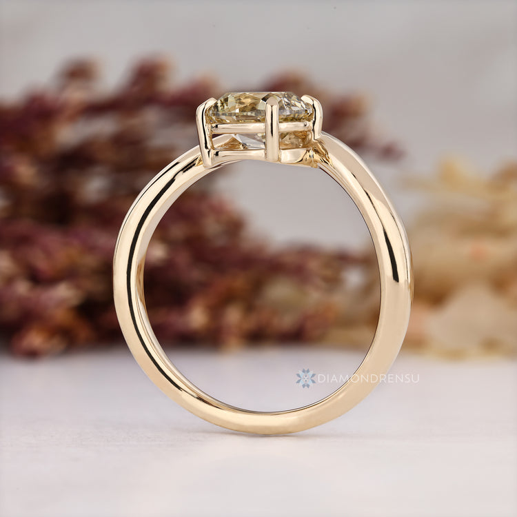 Cushion cut solitaire diamond ring with four claw prongs.