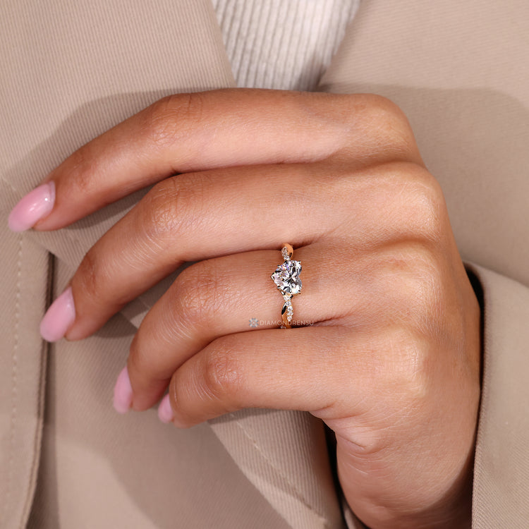 Heart cut diamond ring with round diamonds.