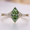 Marquise cut diamond ring with green diamond.