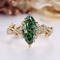 Marquise diamond ring with green diamond accent.