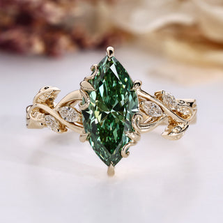 Marquise diamond ring with green diamond accent.