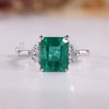 Emerald cut emerald ring half moon three stone style.
