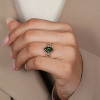 Green diamond ring with round side stones.