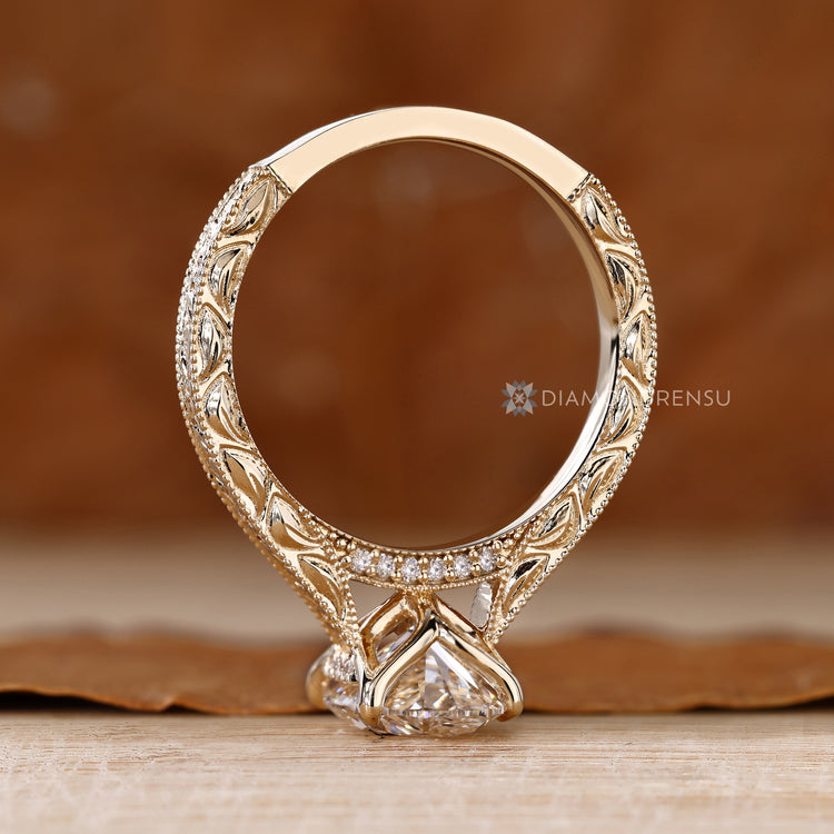 Oval diamond ring with round diamond bridge accents.
