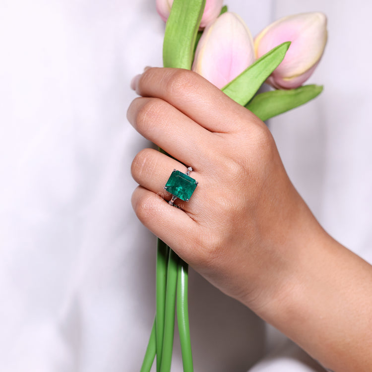 Emerald cut emerald ring four prong pave band style.
