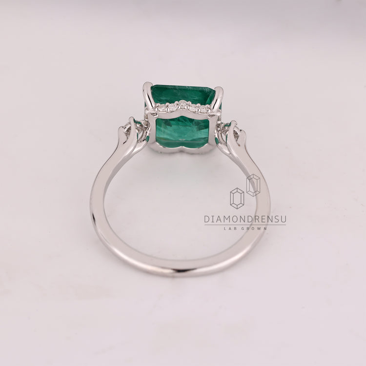 Emerald gemstone ring open gallery prong set style.
