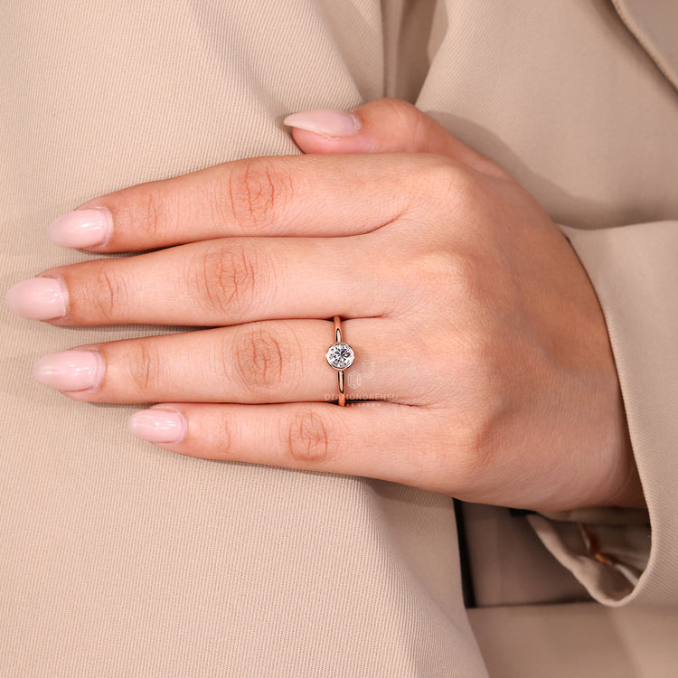 Minimal solitaire diamond ring in bezel setting.
