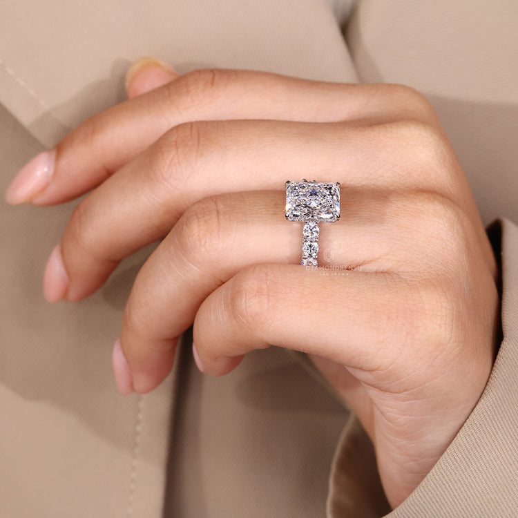 Radiant cut ring with hidden halo and round diamonds.
