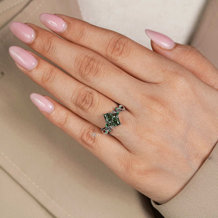 Green diamond ring with marquise and round side gemstones.