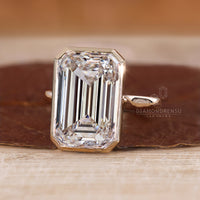Emerald cut diamond ring in a bezel setting.