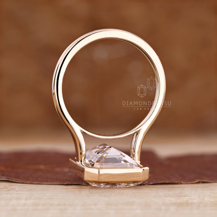 Cathedral setting ring with bezel set emerald cut diamond.