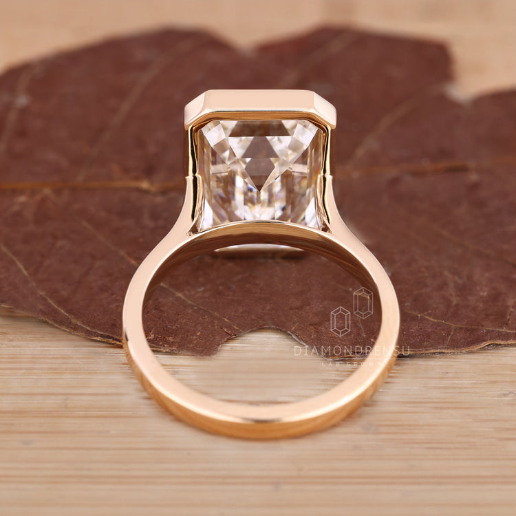 Custom diamond ring with emerald cut solitaire design.