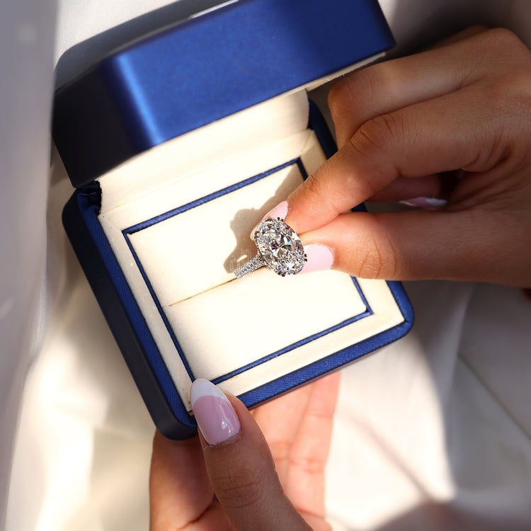 Pave round diamond ring featuring oval centre stone.