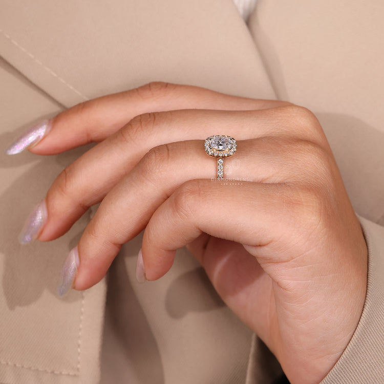 4 Claw Prong Ring holding oval cut diamond in halo style.
