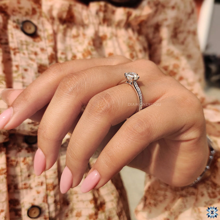 Moissanite engagement ring with hexagon design and round cut pave setting.
