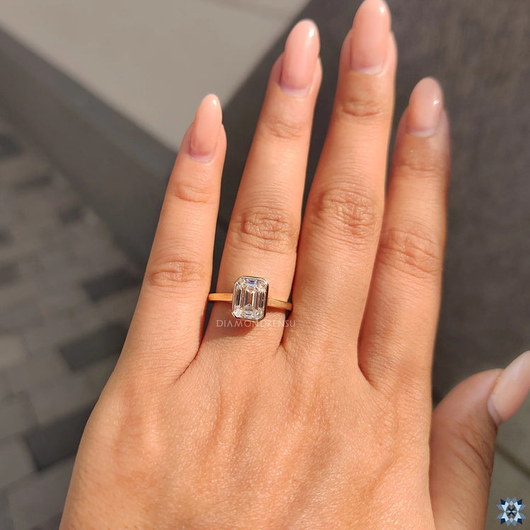 Emerald cut engagement ring, a perfect solitaire design in yellow gold.
