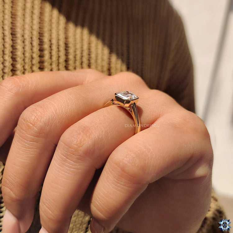 Handmade jewelry, featuring a bezel set Emerald cut engagement ring.