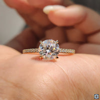 Unique engagement ring with a round cut diamond and yellow gold pave setting