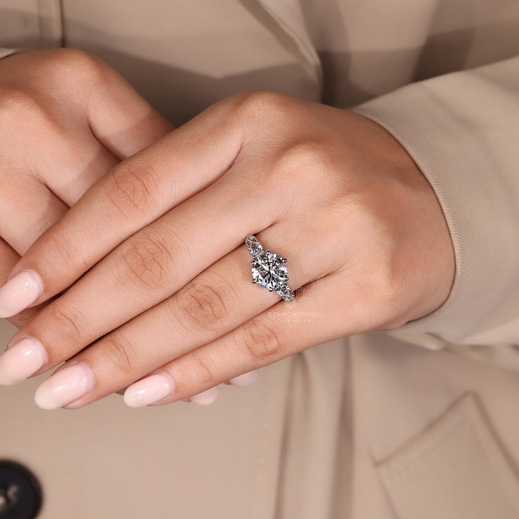Round diamond ring with pear side stones.
