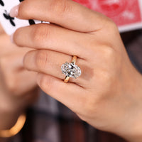 Hidden halo round diamond ring with oval centre stone.