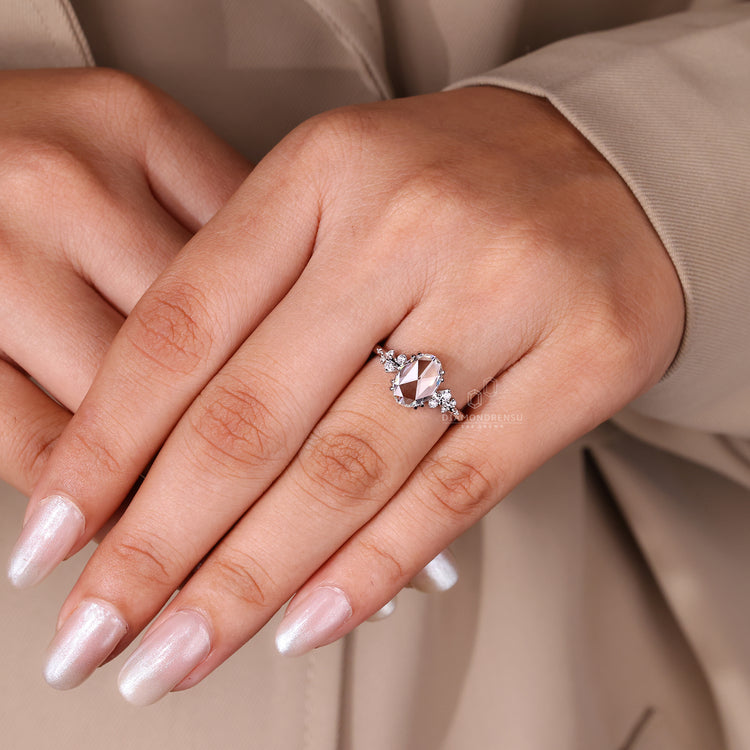 Cluster style oval rose cut diamond ring with side stones.

