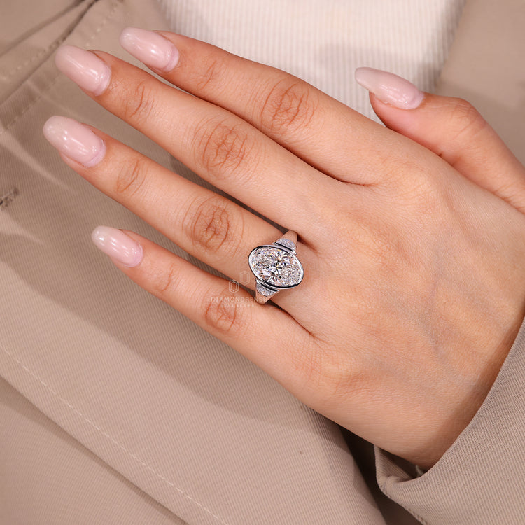 Oval cut diamond ring with bezel setting.
