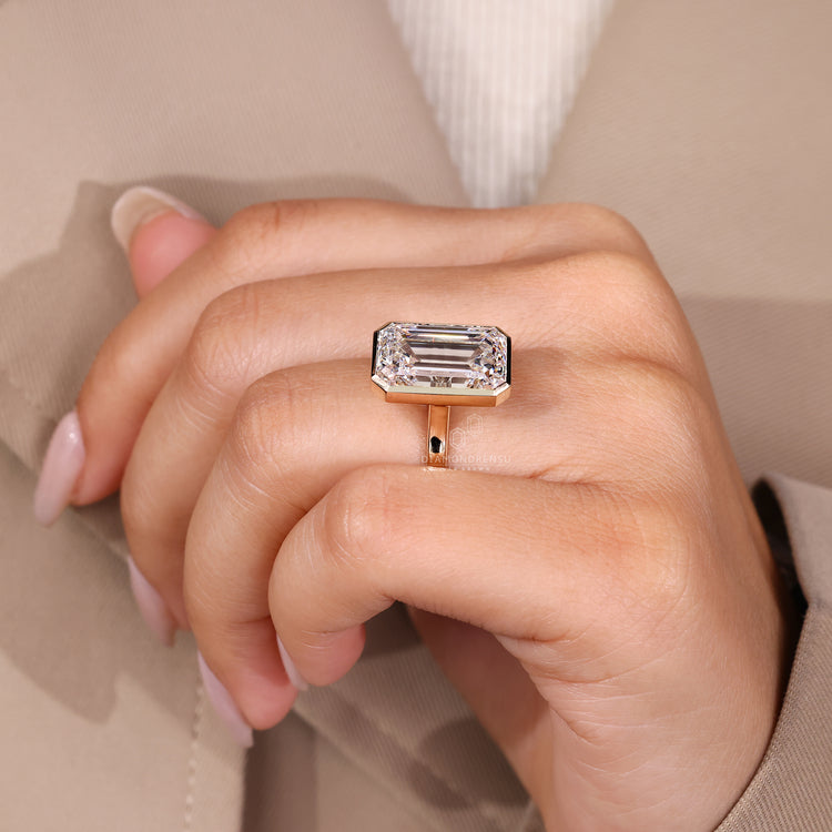 Handmade ring featuring bezel set emerald cut diamond.